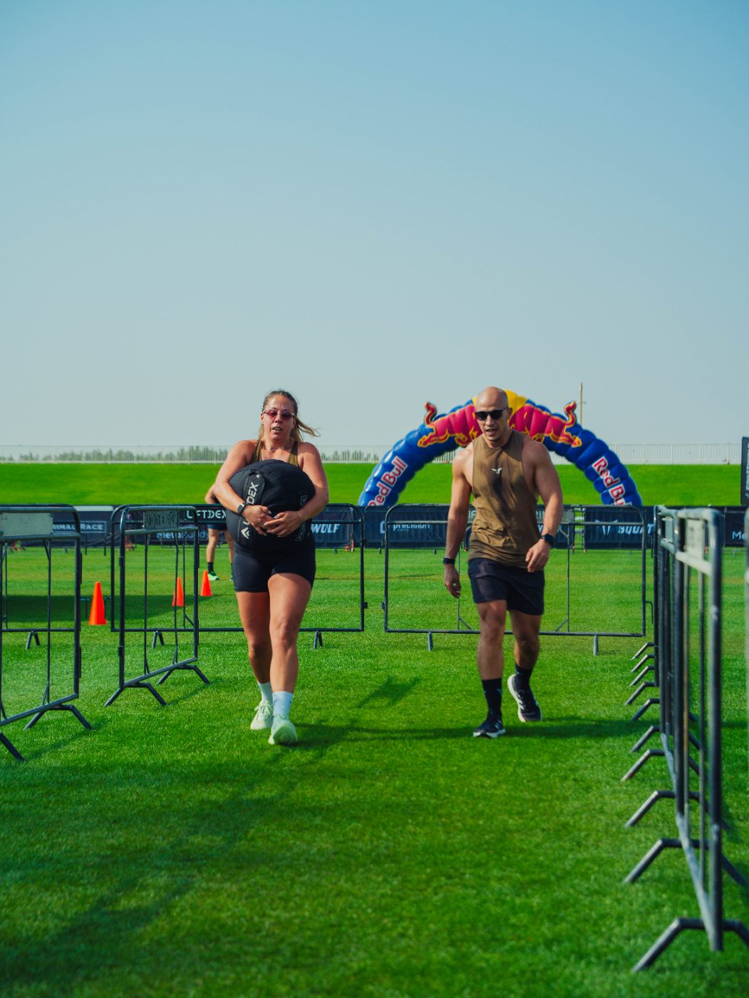Two athletes running out of the finish arch at a Primal race