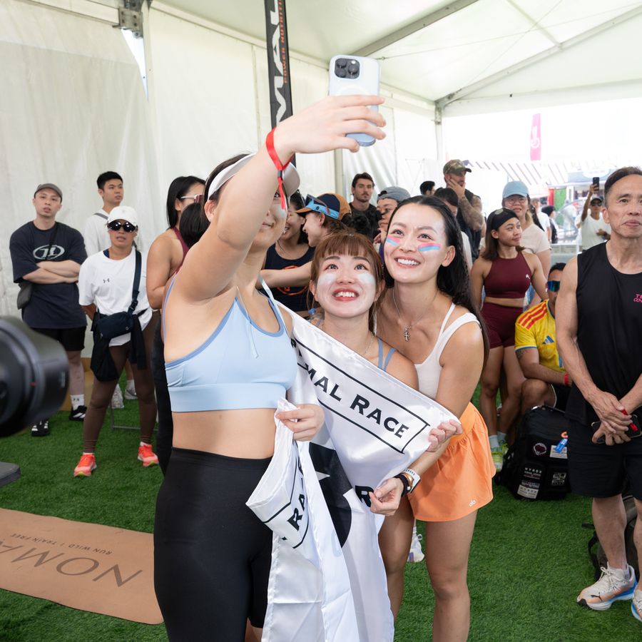 Athletes taking a photograph with a Primal flag