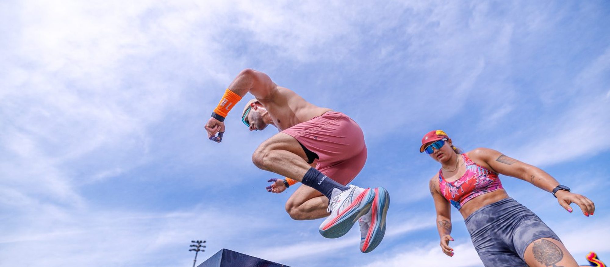Two athletes airborne over the box at a Primal race