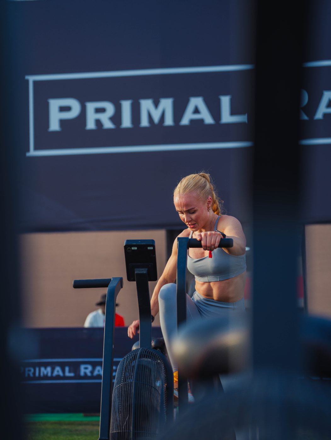 An athlete on the echo bike behind the Primal Race board